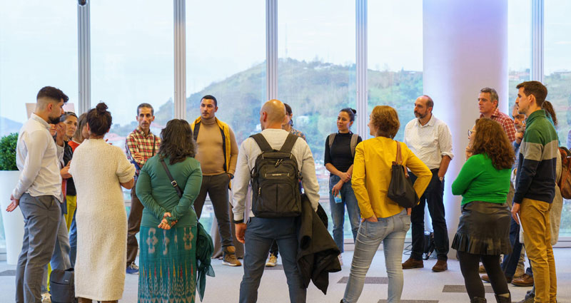 Un grupo de unas 20 personas charlan en círculo en el interior de la Torre Iberdrola
